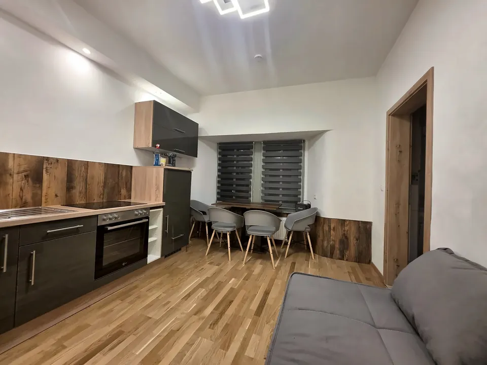 Küchenzeile mit Backofen, im Vordergrund das Schlafsofa