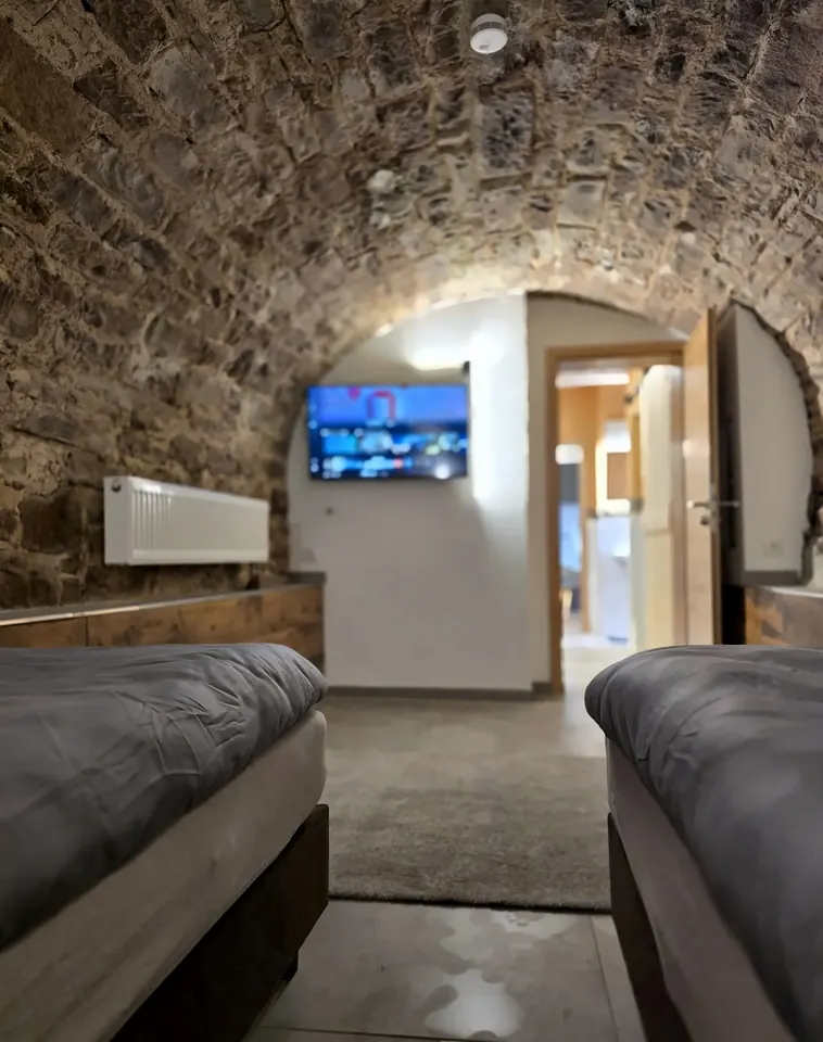 Blick aus dem Gewölbezimmer Richtung Tür mit Fernseher
